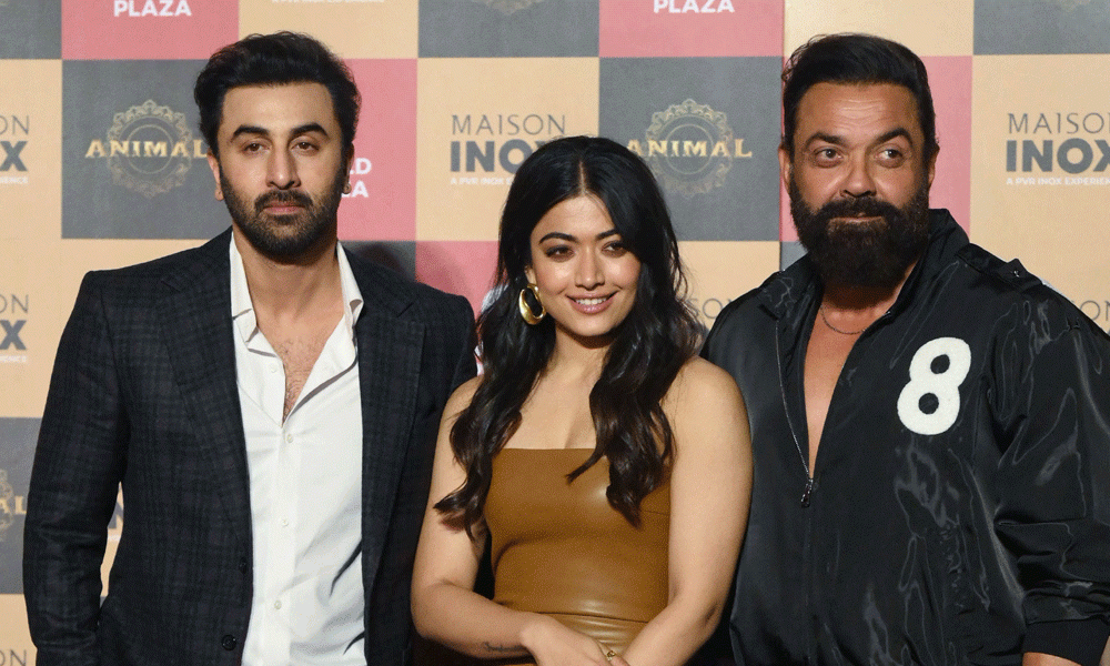 Bollywood actors Ranbir Kapoor (L), Bobby Deol (C) and Rashmika Mandanna (R) pose for a photograph during the promotion of their upcoming film 'Animal' in Mumbai on November 30, 2023. Photo : AFP
