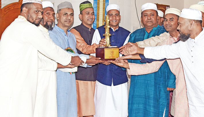 M Anwar Hossain hands over a trophy to the winners