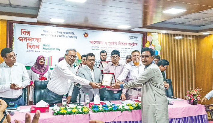 Rangpur Divisional Commissioner Md Zakir Hossain hands over a crest to Itakumari Union Parishad Chairman Abul Basar as Itakumari became best union at district level on Sunday. Civil Surgeon Office and District Family Planning Department organised the award distribution programme on the occasion of Population Day where Rangpur Deputy Commissioner Mohammad Mobasher Hasan was also present.  –Daily Sun Photo