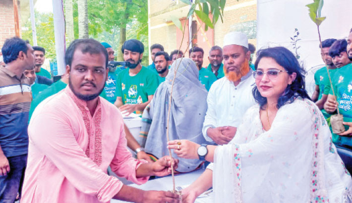 Singra Upazila Awami League Vice-President and chief of social organisation ‘Alokito Somaj’ Arifa Jesmin Kanika distributes sapling among people under the Chalan Beel Tree Plantation campaign 2024 near upazila food warehouse intersection on Monday. A total of 1 lakh saplings will be distributed during the event. –Daily Sun Photo