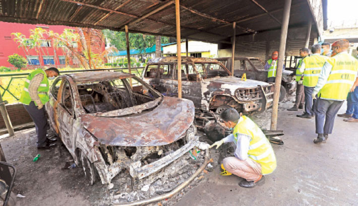 A team of CID on Sunday inspects the burnt-out cars which were set afire by miscreants at the building of Bangladesh Television during the quota reform movement in the city. ––– Kamrul Islam Ratan