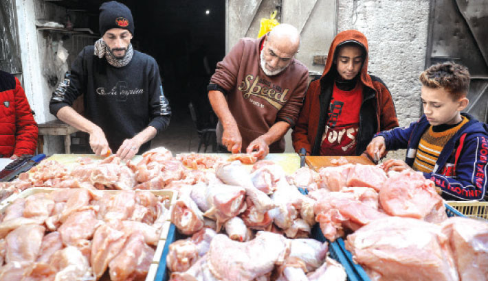 Butchers prepare defrosted poultry meat for sale at a market in Deir el-Balah in the central Gaza Strip on 12 January 2025 amid the ongoing war in the Palestinian territory between Israel and Hamas. Photo: AFP