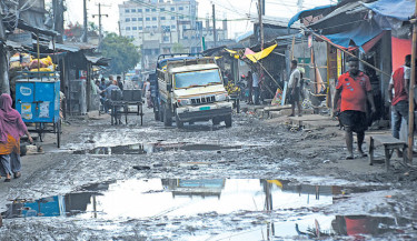 Vehicles navigate a dilapidated, muddy road damaged by rain in Bakulia Shutki Palli area on Friday, causing hardship for traders and local residents. -Rabin Chowdhury