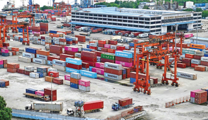Trucks queue next to containers at the Myanmar Industrial Port along the Yangon River in Yangon on Friday. PHOTO: AFP