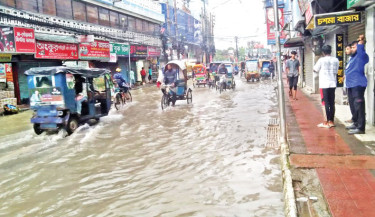 Vehicles crawl as pedestrians wade through ankle-deep water on a waterlogged road in Barishal Sadar on Friday, after days of continuous rainfall.  -  FOCUS BANGLA