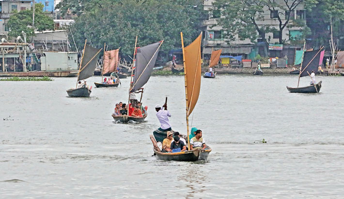 Sails catch the wind as boats glide across the Buriganga River, carrying passengers over waters that are usually murky, now brightened by the season’s rains. The photo was taken in he capital’s Shyampur on Saturday. - KAMRUL ISLAM RATAN
