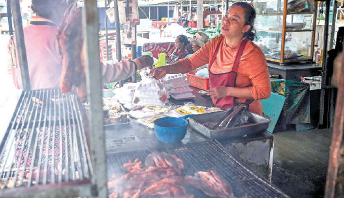 A woman (L) buys food at a market in Samraong, some 20 kilometres from the border conflict zone, in Cambodia's Oddar Meanchey province on 27 July 2025. Thailand and Cambodia clashed for a fourth day on 27 July, despite both sides saying they were ready to discuss a ceasefire after a late-night intervention by US President Donald Trump. Photo: AFP