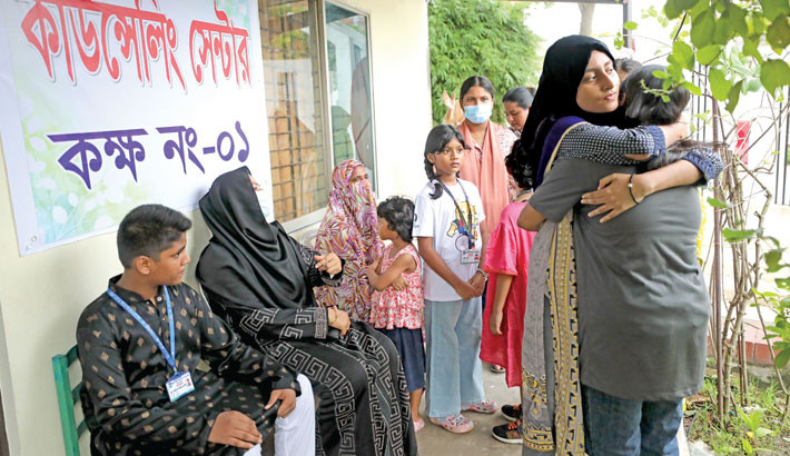 One person comforts another with a hug as Milestone School and College provides daily counselling from 9am to 4pm to help students, guardians, teachers, and staff recover emotionally following the fighter jet crash. The photo was taken on Tuesday. Kamrul islam ratan