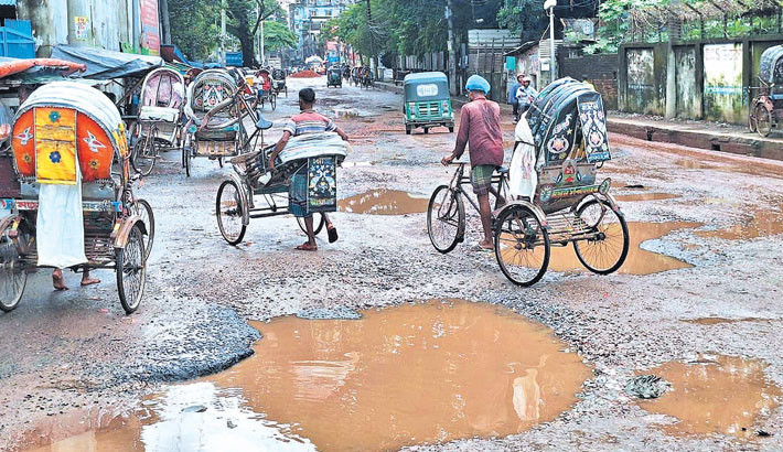 Water-filled potholes dot Sadarghat Road in Chattogram, causing severe suffering for daily commuters and residents. The photo was taken on Wednesday. - RABIN CHOWDHURY
