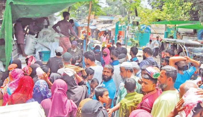 People gather in front of an Open Market Sale (OMS) truck near Azimpur Chapra Mosque, Dhaka, to purchase rice and flour on Sunday. 
PHOTO: FOCUS BANGLA
