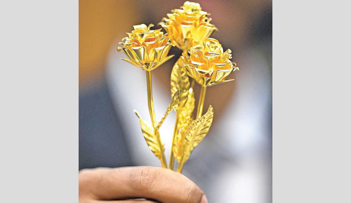 A man shows a rose-shaped, 24-karat gold piece, weighing one ounce (31.1 grams) on sale for KD 1,200 (around $4,000 US) at the central gold market in Kuwait City on 5 August 2025. - PHOTO: AFP
