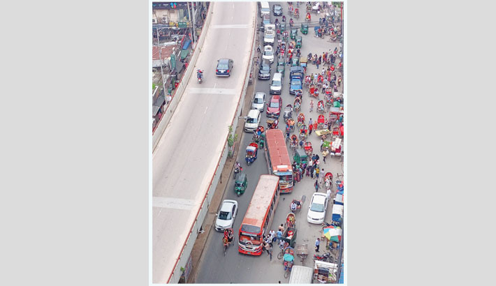 A bus stops to pick up passengers in the middle of the busy Moghbazar Wireless Gate road, causing traffic congestion. Such a practice is widespread among bus drivers in Dhaka and continues to significantly disrupt the city’s traffic flow. The photo was taken on Thursday.-Reaz Ahmed Sumon