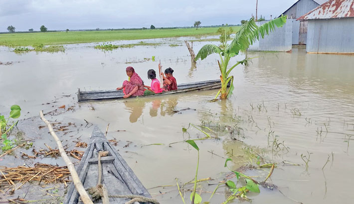 A woman and her children travel in a makeshift boat through a flooded low-lying area in the northern region of the country. Continuous heavy rainfall in recent days, combined with the onrush of water from upstream, have caused flooding that stranded thousands of residents along the Teesta riverbank. The photo was taken on Wednesday. -  Amanur Aman