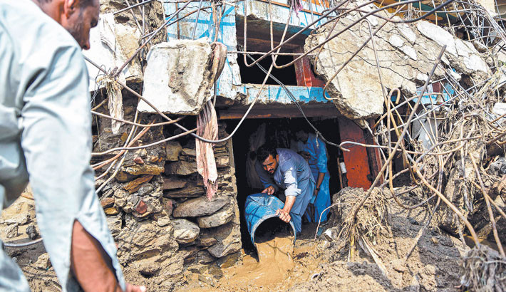 A resident removes sludge from his damaged house a day after flash floods in the Buner district of the monsoon-hit northern Pakistan's mountainous Khyber Pakhtunkhwa province on Saturday. Rescuers were struggling to retrieve bodies from debris after flash floods triggered by heavy monsoon rains across northern Pakistan killed at least 340 people in 48 hours, authorities said.  -  AFP PHOTO