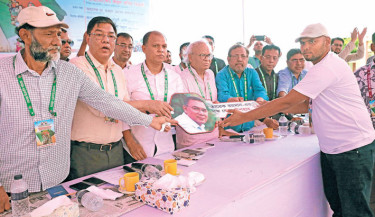 BNP Joint Secretary General Ruhul Kabir Rizvi hands over a dummy key to an auto-rickshaw driver at a financial donation and auto-rickshaw distribution event organised by the "Amra BNP Poribar" at Dewanganj Girls High School grounds in Jamalpur on Wednesday.-Kamrul Islam Ratan