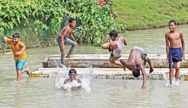 Children enjoy a refreshing bath in a waterbody amid the scorching summer heat. The photo was taken in Kattali area in Chattogram on Friday.  -  RABIN CHOWDHURY