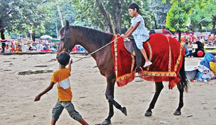 One child enjoys a carefree horse ride draped in red velvet, while another, in a quiet twist of fate, leads the horse for a living as two childhoods cross paths at Dhaka’s Central Shaheed Minar on a weekend afternoon.  -  FOCUS BANGLA