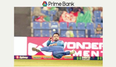 Rashid Khan throws the ball off his own bowling during the match against Sri Lanka at the Zayed Cricket Stadium in Abu Dhabi on Thursday.  -  TANVIN TAMIM