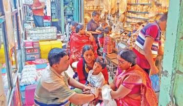 People from the Hindu community throng shops in Old Dhaka’s Shakahribazar to buy shakha (traditional white bangles made of conch shell, worn by married Hindu women) and churi (glass bangles, usually colourful and decorative) ahead of their biggest festival, Durga Puja. The photo was taken on Saturday.	 FOCUS BANGLA PHOTO