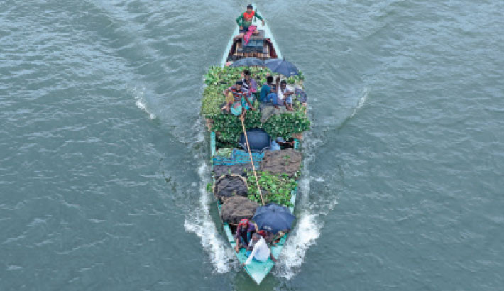 Traders glide along the Buriganga River on a boat heaped with fresh vegetables from Dhaka’s outskirts, making their way toward Shyam Bazar in Old Dhaka on Tuesday. -Reaz Ahmed Sumon