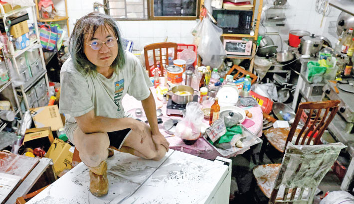 A resident sits on top of a refrigerator in a mud-covered kitchen after flooding brought by Super Typhoon Ragasa in Hualien, Taiwan, on Thursday.- REUTERS PHOTO