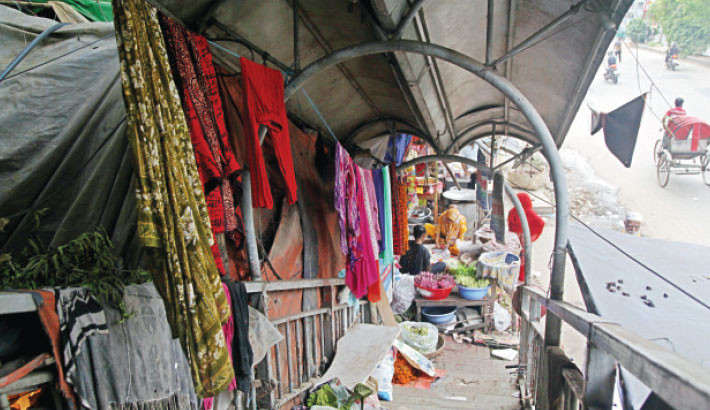 A footbridge in the capital’s Shahbagh has been turned into a makeshift business and living space by some homeless individuals, with household items blocking the walkway and forcing pedestrians to take alternative routes. The snap was taken on Monday. -Nazmul Islam