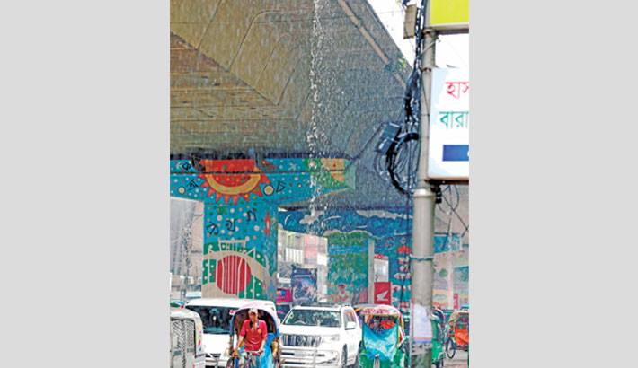 Commuters get suddenly drenched and traffic gets disrupted as broken water delivery pipes under the Mouchak-Moghbazar flyover gush water following a rain on Tuesday. -Kamrul Islam Ratan