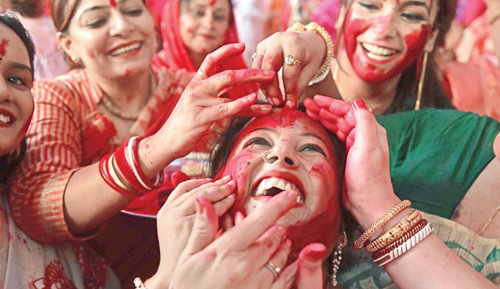 Hindu devotees take part in Sindoor Khela ritual where married women anoint each other with vermilion powder on the final day of the Durga Puja festival in Chandigarh, India on Thursday.	-AFP PHOTO
