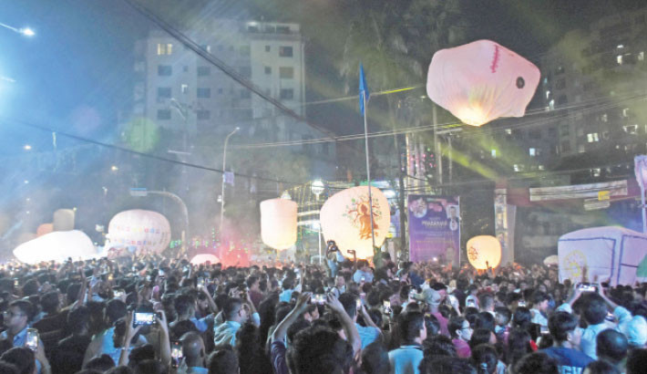 Under the night sky of DC Hill in Chattogram, members of the Buddhist community release colourful wishing lanterns (fanush) and capture moments in celebration of the Probarona Purnima festival on Monday. -Rabin chowdhury