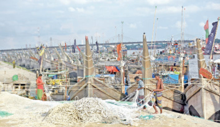 Fishermen mend their nets along the bank during the 22-day ban on fishing in the country’s seas and rivers. The photo was taken from the Fisherighat area in Chattogram. -Rabin chowdhury