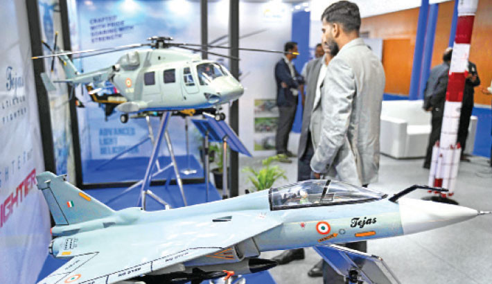 Visitors walk past “Tejas light combat aircraft” model displayed during AeroDefCon 2025, at the trade center in Chennai on 7 October 2025. -Photo: AFP