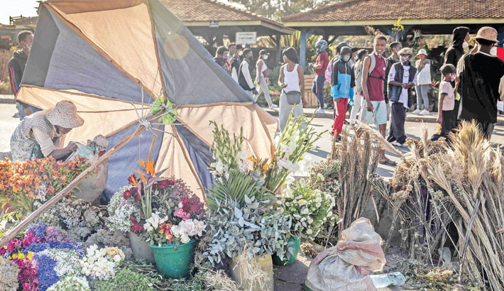 A flower vendor takes cover as she protects her stall while protesters gather during a demonstration demanding constitutional reforms in Antananarivo, on 7 October 2025 President Andry Rajoelina's appointment of an army general as new prime minister was met with little enthusiasm in Madagascar Tuesday and dismissed by the youth-led movement behind two weeks of protests as a diversion. PHOTO: COURTESY