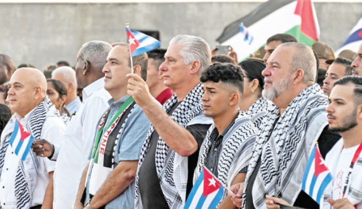 Cuba’s President Miguel Diaz-Canel, wearing a keffiyeh, waves a Cuban flag during a demonstration in support of the Palestinian people outside the US Embassy in Havana, on Thursday.-AFP PHOTO