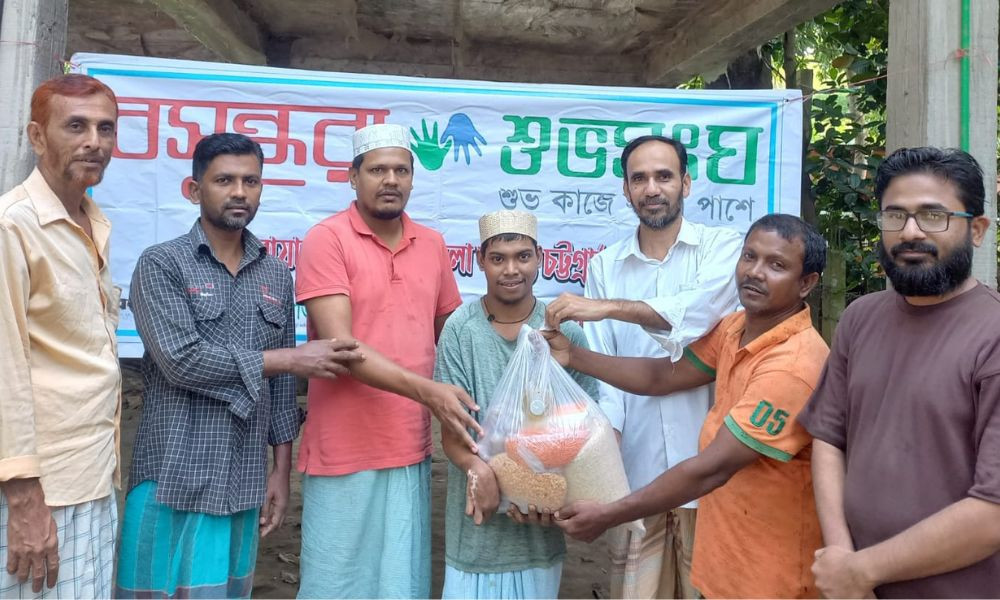Bashundhara Shuvosangho stands beside rickshaw-puller Mohiuddin with food aid