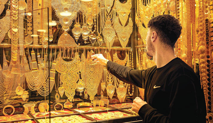 A salesperson displays gold bracelets and necklaces for sale in a gold shop at the Grand Baazar in Istanbul, on 10 October 2025. Gram gold reached a historic record level in Turkey at 5,500 Turkish Lira (113,60 euros) on 9 October 2025, causing increased demand at jewelers in the Grand Bazaar of Istanbul. PHOTO: AFP
