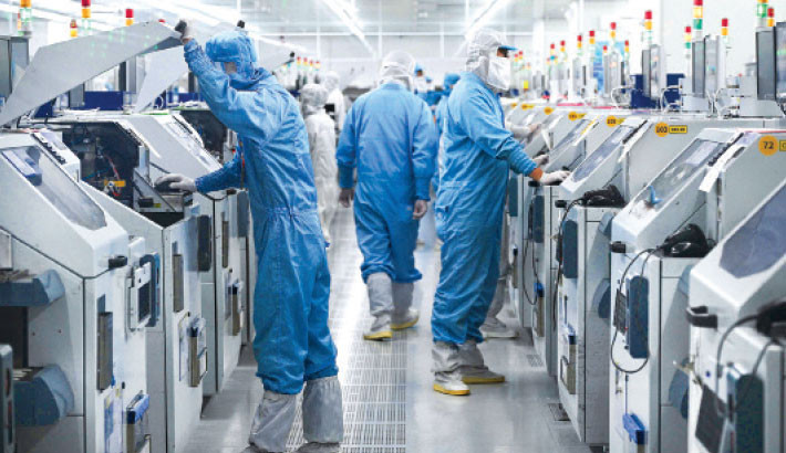 Technicians work on chip processing equipment at a semiconductor manufacturing plant in Suqian, in eastern China’s Jiangsu province on Monday. PHOTO: AFP