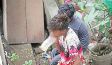 Two street children sniff “Dandy”, a toluene-laced glue meant especially for mending shoes, from tattered polythene bags -- a haunting emblem of rising addiction and the bitter truths of childhood hardship. The photo 
was  shot from the capital’s 
Khilkhet area on Monday.  
-Nazmul Islam